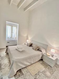 Un dormitorio blanco con una cama grande y una ventana en Tuna House en Carloforte