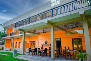 a patio with tables and chairs in front of a building at Saayoo Resort in Negombo