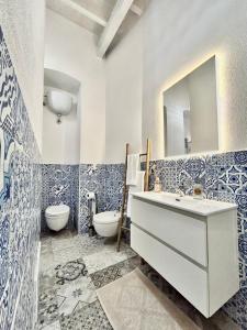 bagno con lavandino, servizi igienici e specchio di Tuna House a Carloforte