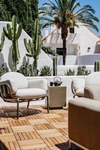 two chairs and a couch on a patio with cactus at Super Stylish Apartment in Fantastic Location in Marbella