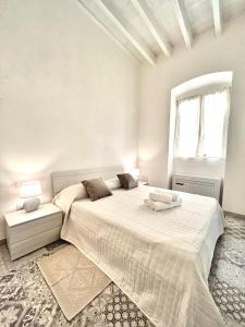 a white bedroom with a large bed and a window at Tuna House in Carloforte
