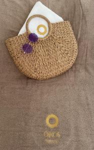 a wicker purse sitting on top of a couch at Oikos Sani Suites in Sani Beach