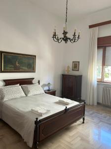 Un dormitorio con una cama grande y una lámpara de araña. en Filly House, en Poggiardo