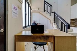 einen Schreibtisch mit Laptop in einem Zimmer mit Treppe in der Unterkunft OYO 92881 Nany Ayahanda Syariah in Medan