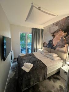 a bedroom with a large bed with a painting on the wall at Art Boulevard in Mrzeżyno