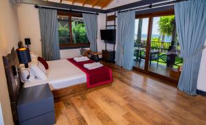 a bedroom with a bed and a television and a balcony at Club Porto Amore Hotel Adults Only in Alanya