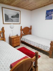 a bedroom with two beds and a night stand and a table at Casa rustica en Lomo Blanco, dentro de una casa rodeada de naturaleza in San Juan de la Rambla