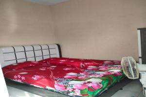 - une chambre avec un lit et une couverture rouge dans l'établissement OYO 92881 Nany Ayahanda Syariah, à Medan