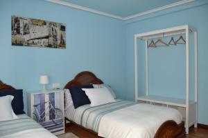 a bedroom with two beds and a blue wall at LA PRENSA in Villamediana de Iregua