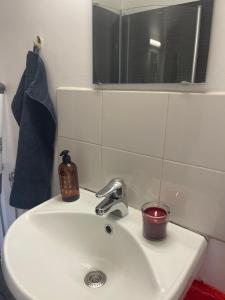 een wastafel in de badkamer met een kaars en een spiegel bij Bergkvara Vandrarhem in Bergkvara