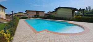 een zwembad in een tuin met een huis bij Apartment Dragonfly - garden and pool in Manerba del Garda