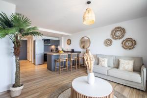 a living room with a couch and a kitchen at New Duplex Fidji in Orient Bay