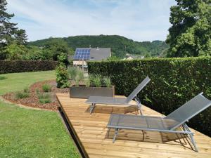 a wooden deck with two chairs and a table at K-Jol et Vous in Aywaille
