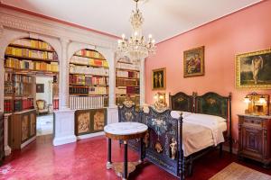 - une chambre avec un lit et un lustre dans l'établissement Villa Augusto, à Cortone