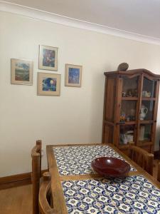 a dining room with a table and a wooden cabinet at Tia Rita House in Figueira da Foz