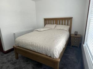 a bedroom with a bed and a night stand at The Secret Nook in Maryport