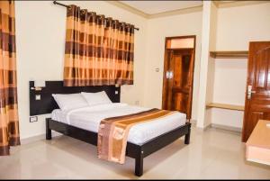 Letto o letti in una camera di Ubuntu Palace Hotel Kampala