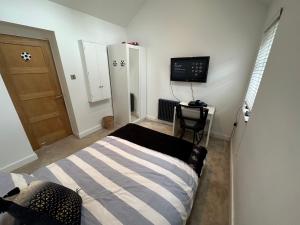 a bedroom with a bed and a television in it at Your Perfect Getaway with Hot Tub in Hale