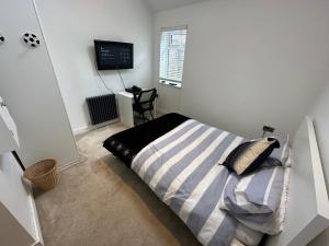 a bedroom with a bed and a television in it at Your Perfect Getaway with Hot Tub in Hale