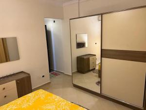 1 dormitorio con espejo, 1 cama y vestidor en Summer vacation flat en Dawwār Ruḩayyim