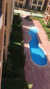an overhead view of a swimming pool next to a building at Summer vacation flat in Dawwār Ruḩayyim