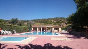a swimming pool with a pavilion and chairs at Cal Ferrer de Tarres in Tarrés