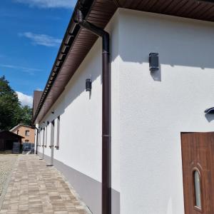 a white building with a metal roof at Przystań nad Sanem in Tyrawa Solna