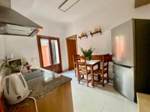 a kitchen with a stainless steel refrigerator and a table at Puerto de Pollensa cat Villas in Port de Pollensa