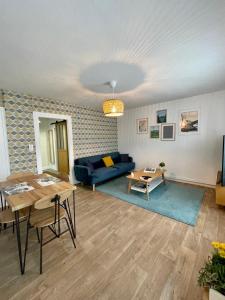 een woonkamer met een blauwe bank en een tafel bij LE MOINET FAYARD in Vichy