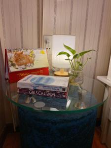 una mesa de cristal con libros encima y una lámpara en CROWNE BUI VIEN Hotel en Ho Chi Minh