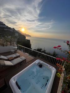 bañera de hidromasaje en una terraza con vistas al océano en SeaJewelsDeluxurySuite, en Amalfi