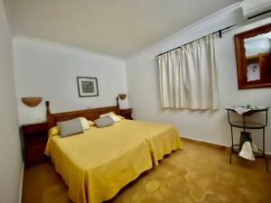 a bedroom with a bed with a yellow blanket at Puerto de Pollensa cat Villas in Port de Pollensa