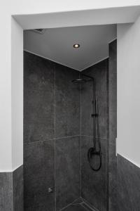 a bathroom with a shower with a glass door at THE URBANIST •inner city residences• in Ioannina