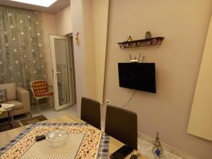 ein Wohnzimmer mit einem Tisch und einem TV an der Wand in der Unterkunft Orkiton House in Durrës