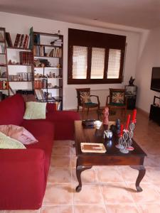 a living room with a red couch and a coffee table at Loft Castelló in Castelló de Farfaña