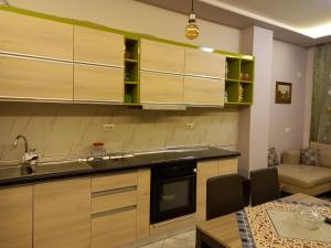 eine Küche mit Holzschränken, einem Tisch und einem Esszimmer in der Unterkunft Orkiton House in Durrës