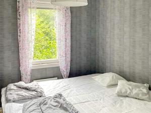 Holiday home UDDEVALLA XL في Sundsandvik: سرير في غرفة مع نافذة وسرير سيد