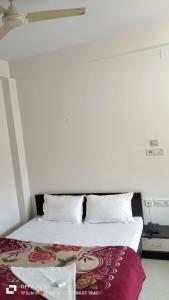 1 dormitorio con 1 cama blanca con sofá cama en HOTEL MTM, en Digha