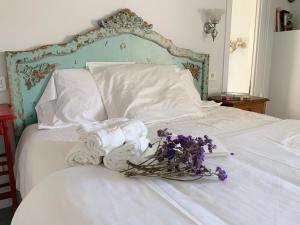 Una cama blanca con toallas y flores. en La Grulla Dorada, en Perales del Puerto
