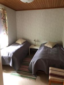- une chambre avec 2 lits, une table et une fenêtre dans l'établissement Röda stugan, à Köpingsvik