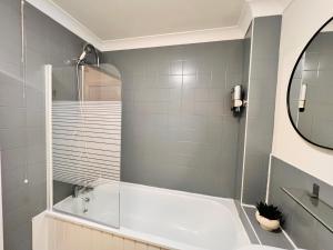 a bathroom with a tub and a mirror at 42i Premium rooms London exactly like the photos in London