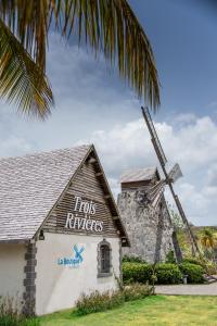 a building with a windmill next to a palm tree at La Villa Didine in Sainte-Luce