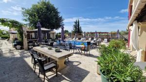 a patio with a table and chairs and a pool at Hôtel Le Mas Des Amandiers in Graveson