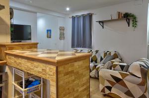 sala de estar con sofá y cocina con barra. en Apartamento Muralla, en Sevilla
