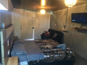 um pequeno quarto com uma cama e uma televisão em Makana apartastudio em Salento