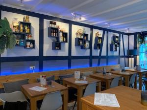a restaurant with wooden tables and chairs in a room at HeimatHerz Hotel Garni in Herdecke