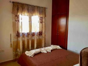 1 dormitorio con cama roja y ventana en Nikitas Luxury House, en Karpathos
