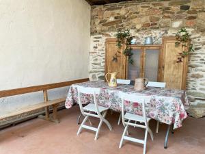 a table and chairs in a room with a stone wall at La Grulla Dorada in Perales del Puerto +41 photos