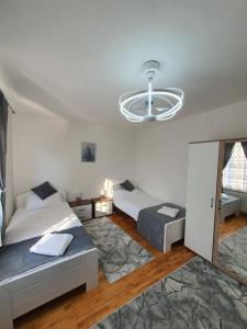 a bedroom with two beds and a chandelier at Sarajevo Central View Apartment in Sarajevo