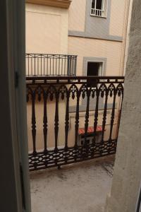 un balcón con una barandilla negra frente a un edificio en Casa Santa Caterina en Massafra